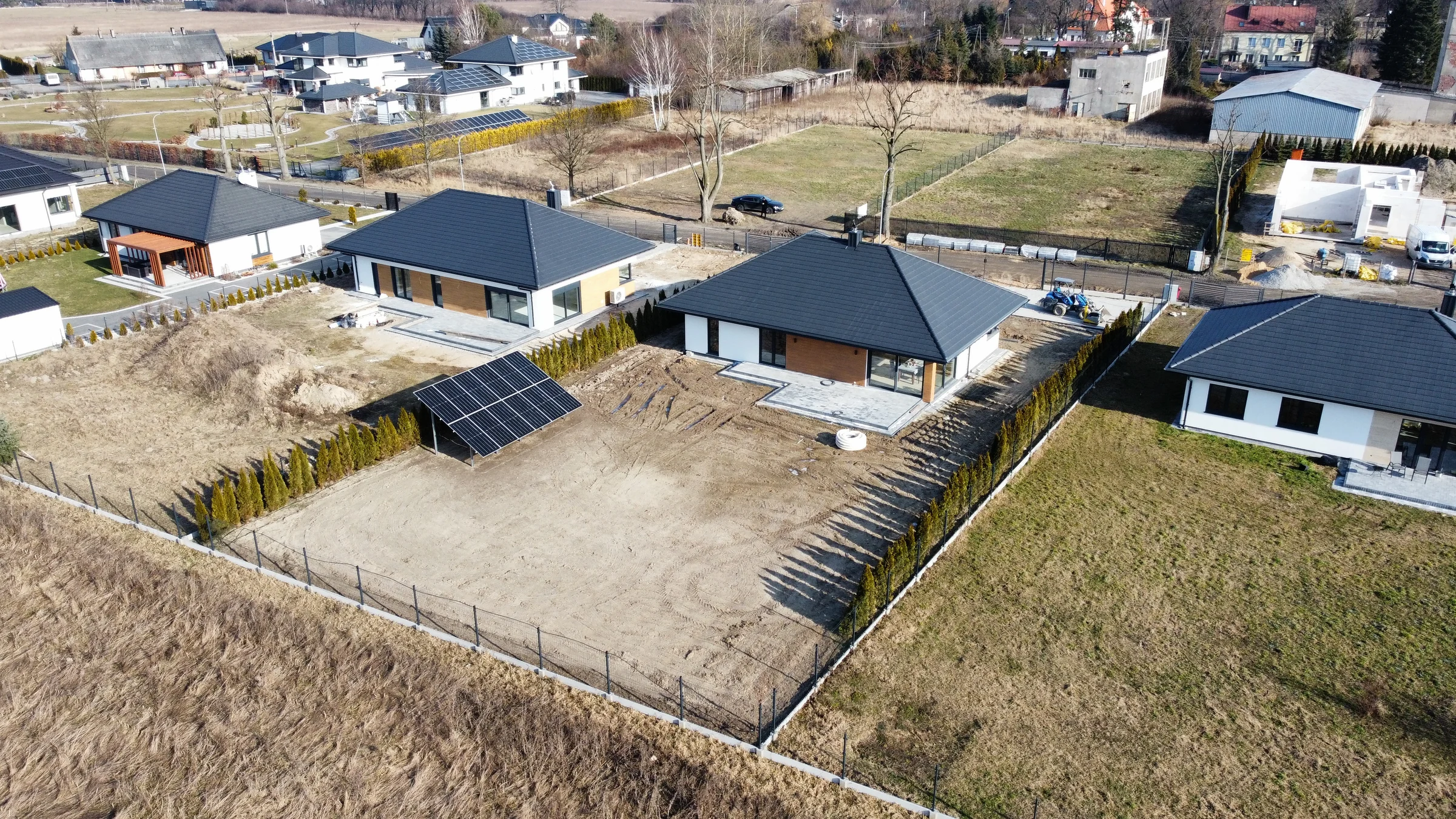Widok z góry instalacji fotowoltaicznej na gruncie przy nowym domu